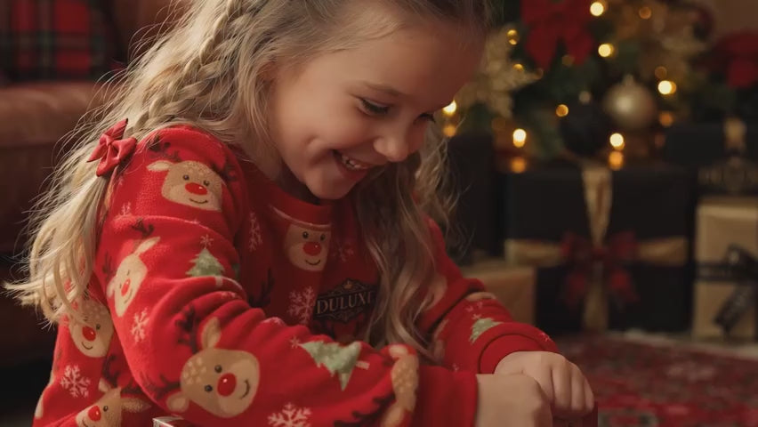 Vidéo démo en français : matin de Noël, enfant en pyjama polaire ouvrant ses cadeaux en famille, présentation DULUXE